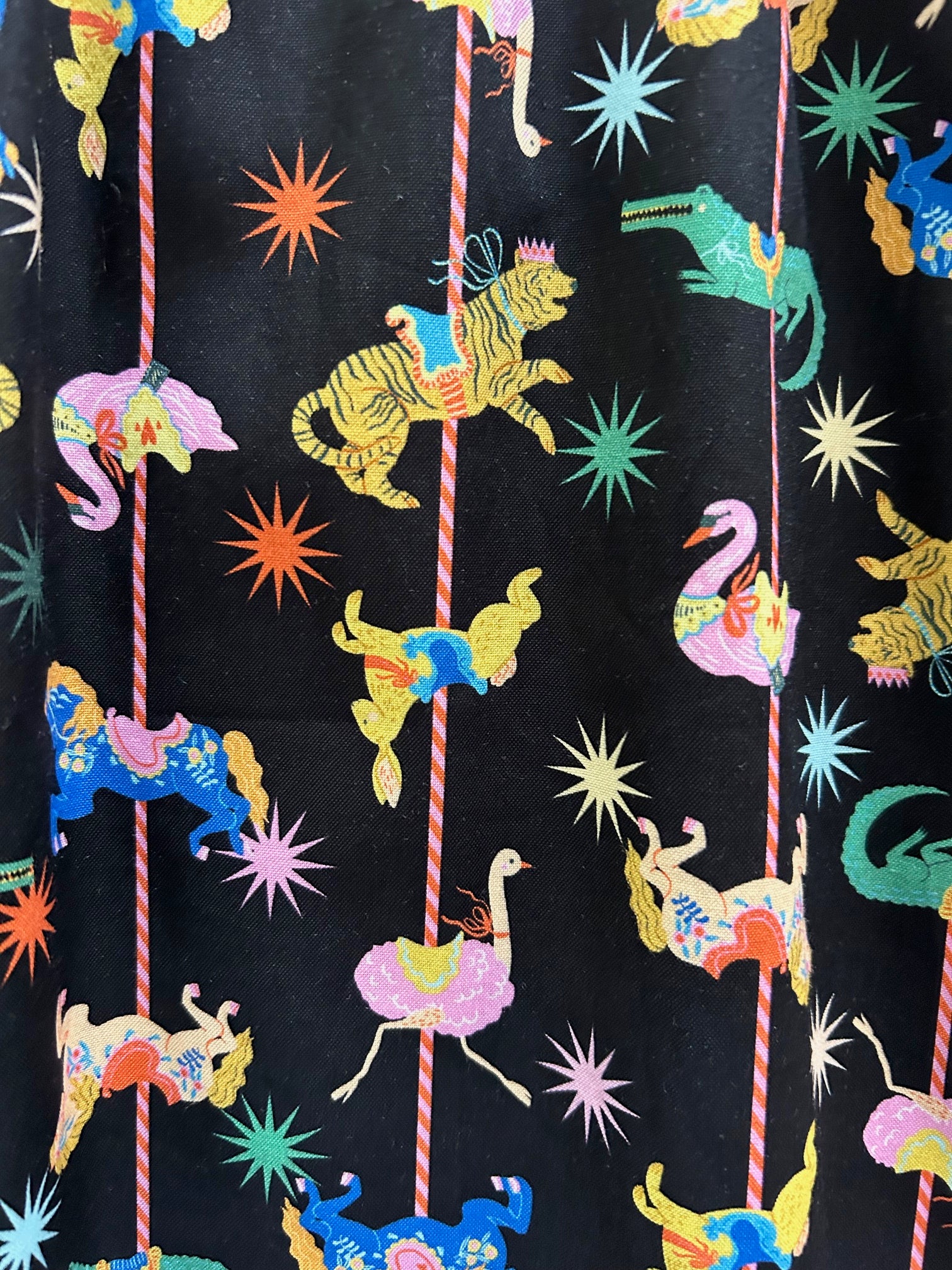 close up of the print showing merry go round animals on black background