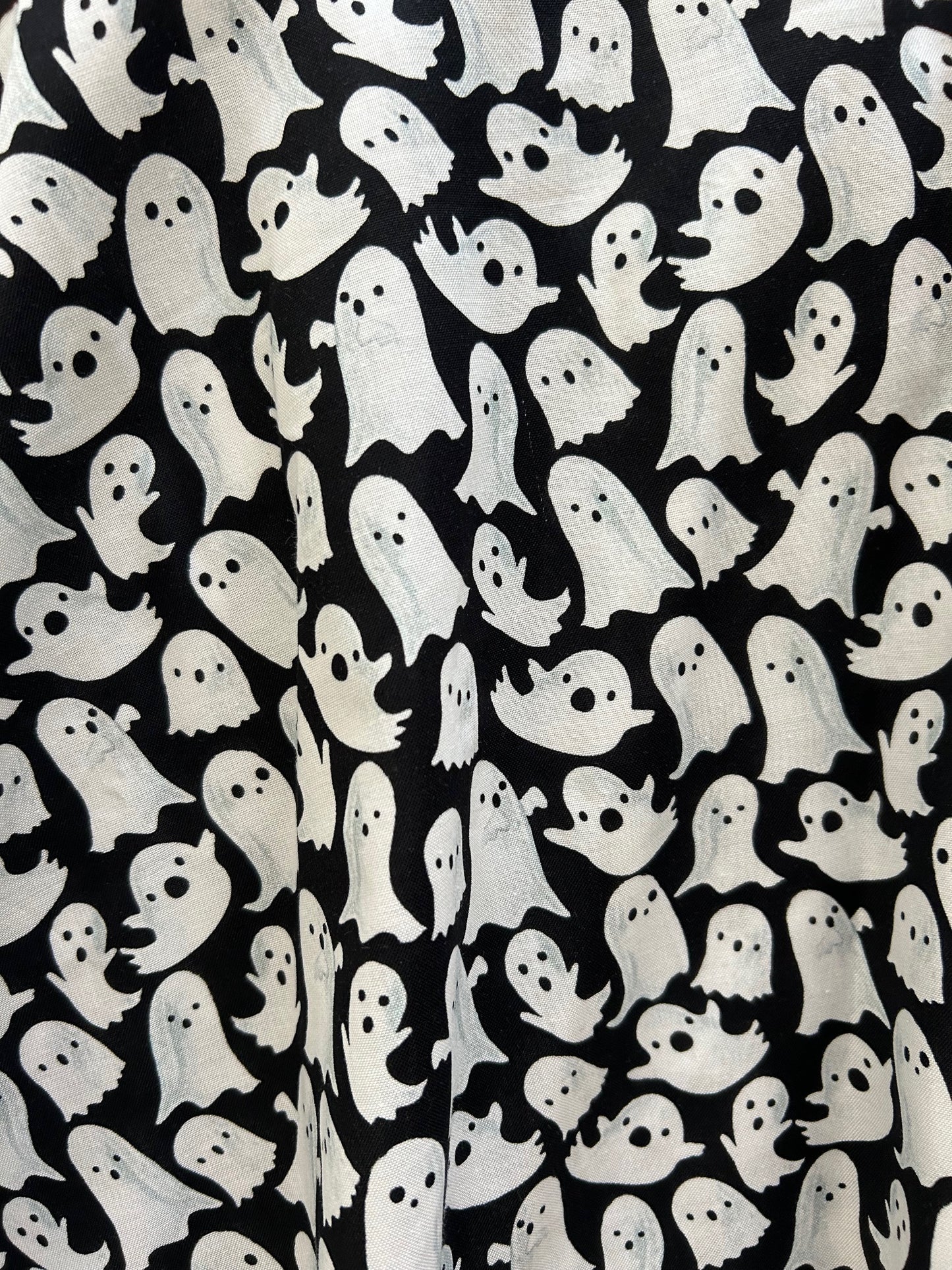 close up of ghost fabric showing white ghosts on black background