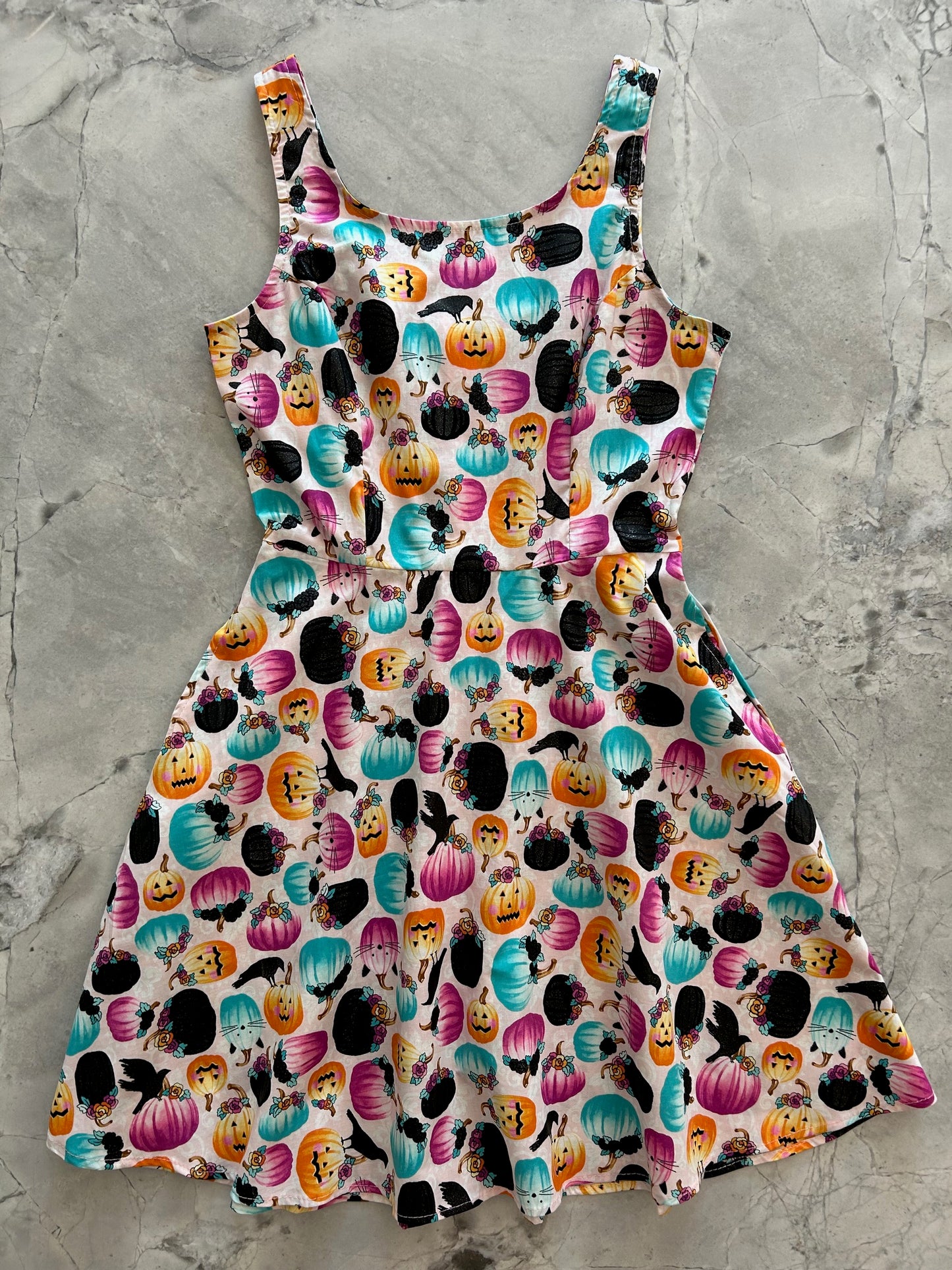 flatlay of pumpkin and crow skater dress