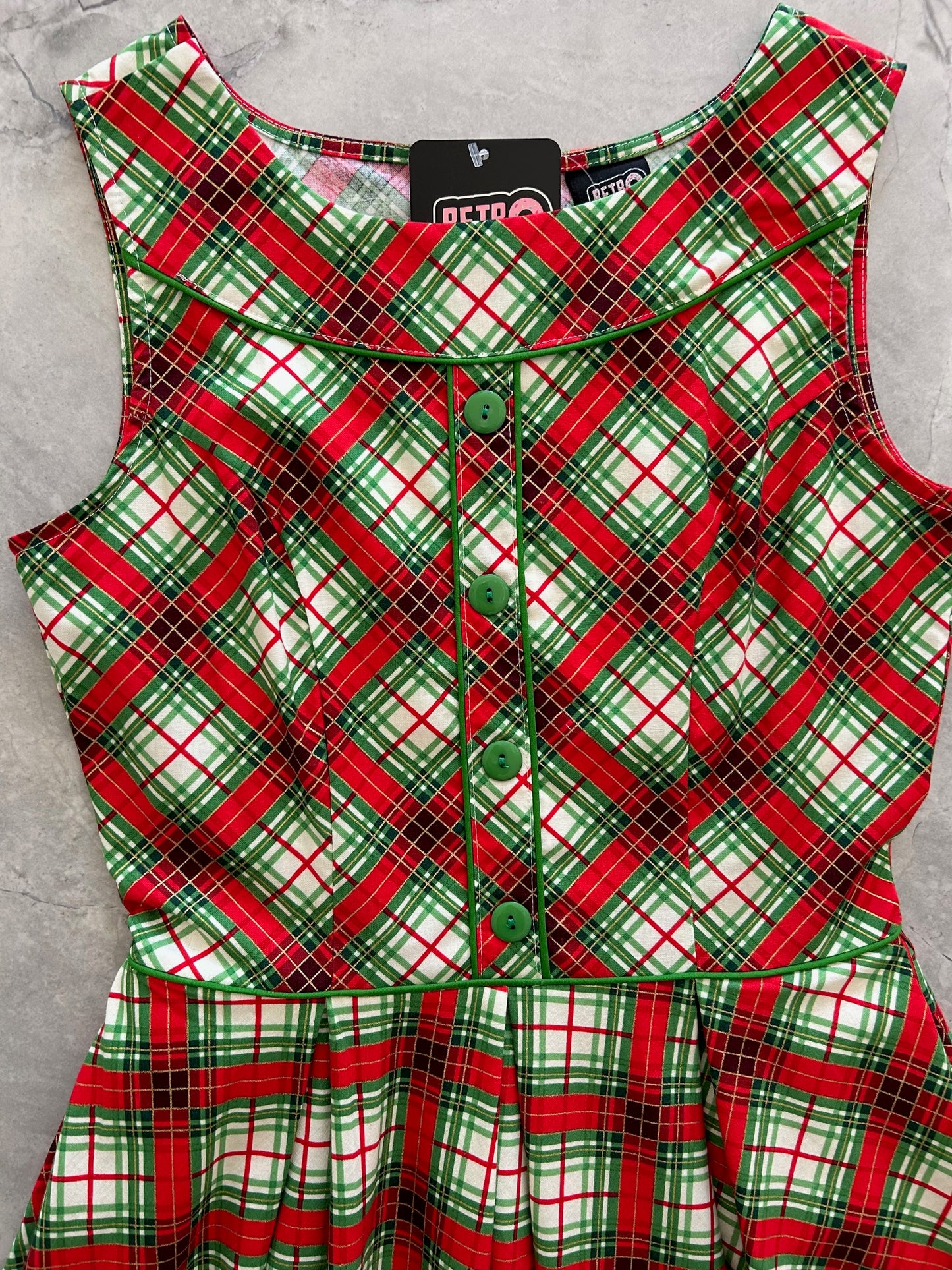 close up of red tartan elizabeth dress showing the green piping and button detail