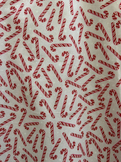 close up of candy cane print showing tossed candy canes on pink background