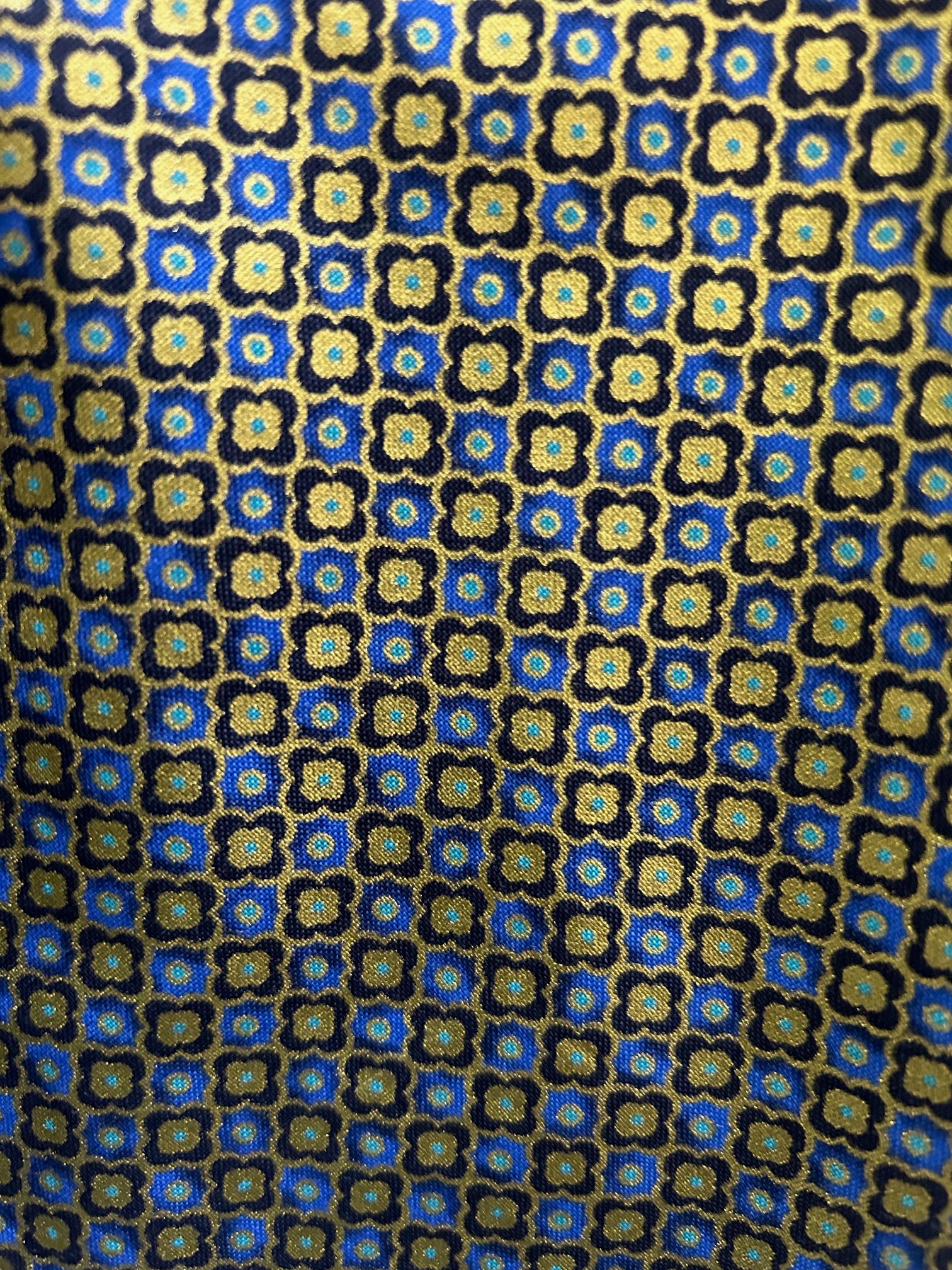 close up of print showing the floral tile print in gold and blue