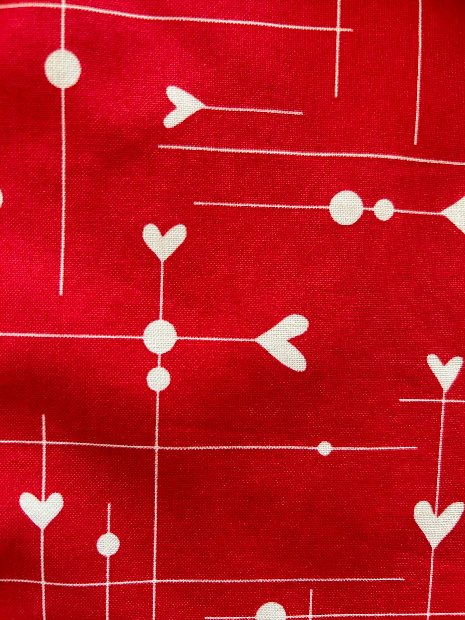 close up of be mine print showing hearts on red background