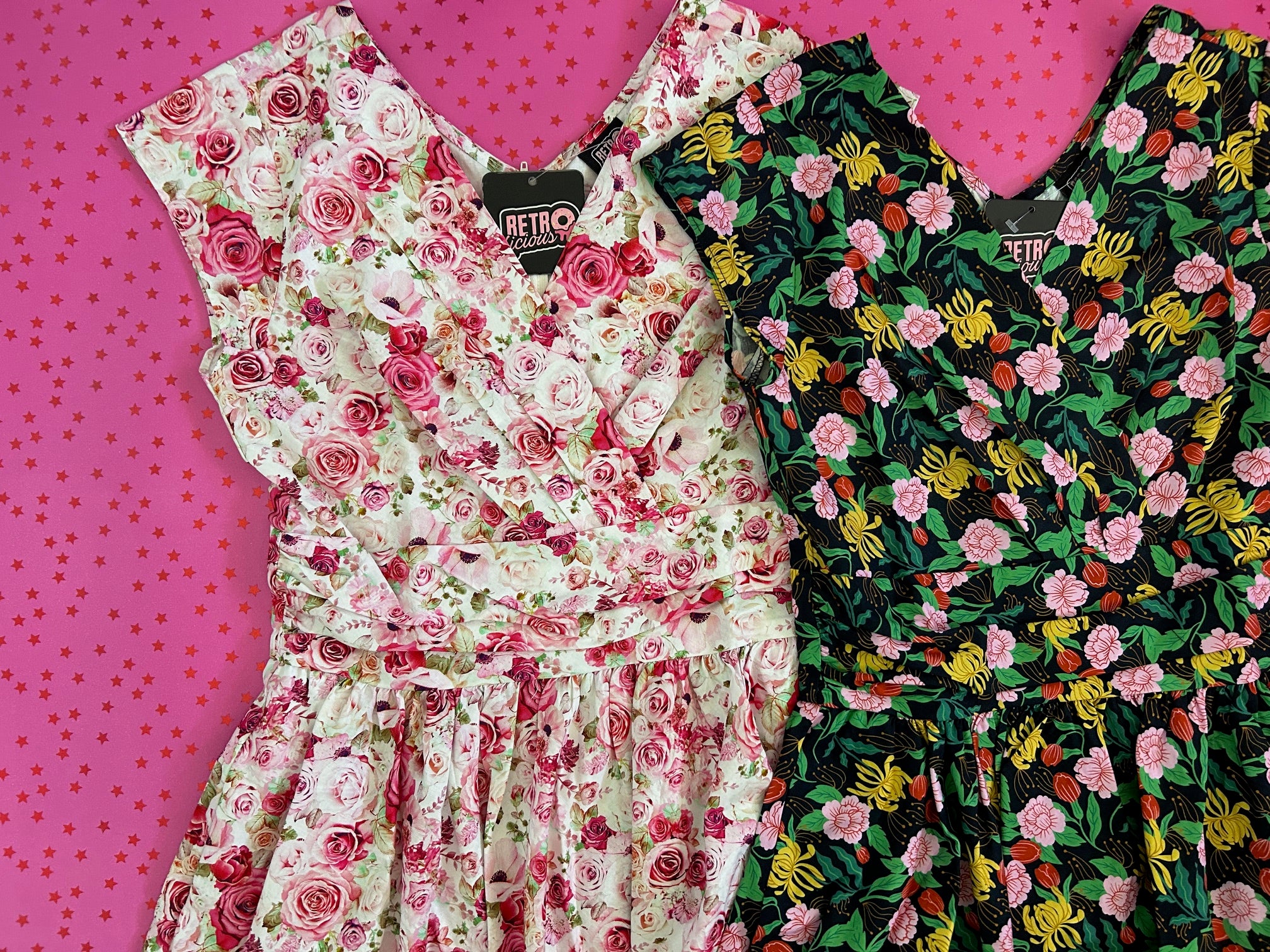 flatlay of two greta dresses on pink star background