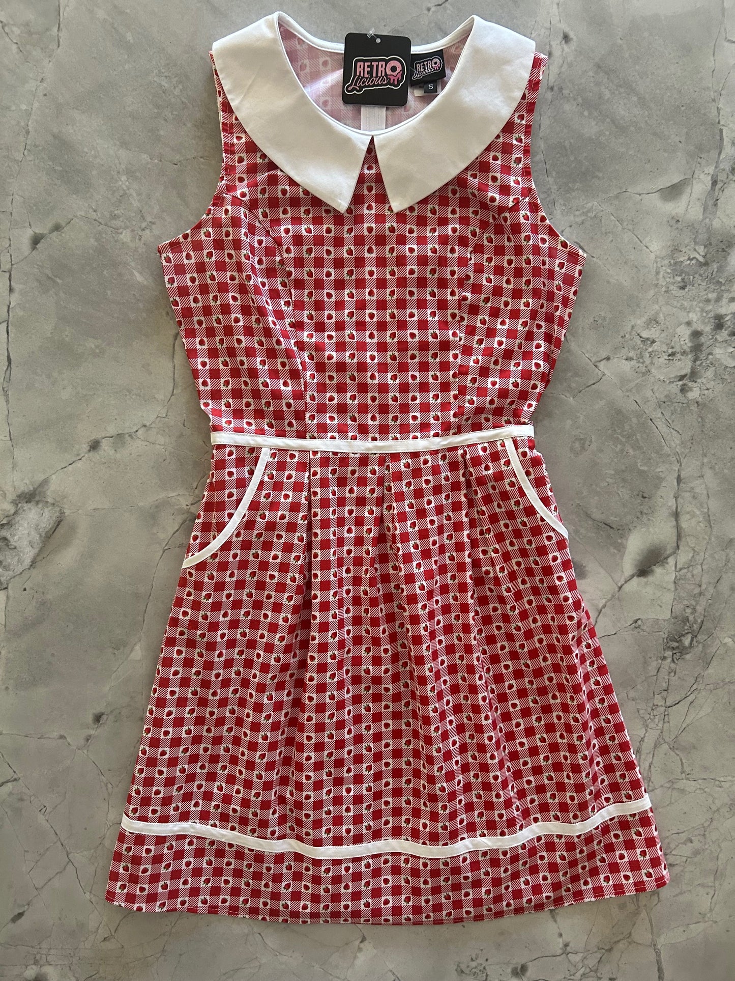 flatlay of strawberry gingham collared dress