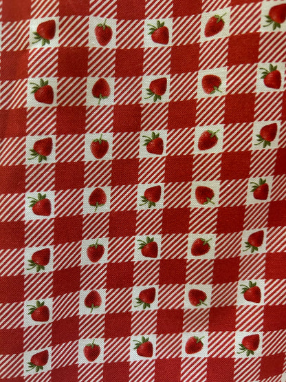 close up of the red and white strawberry print on gingham pattern