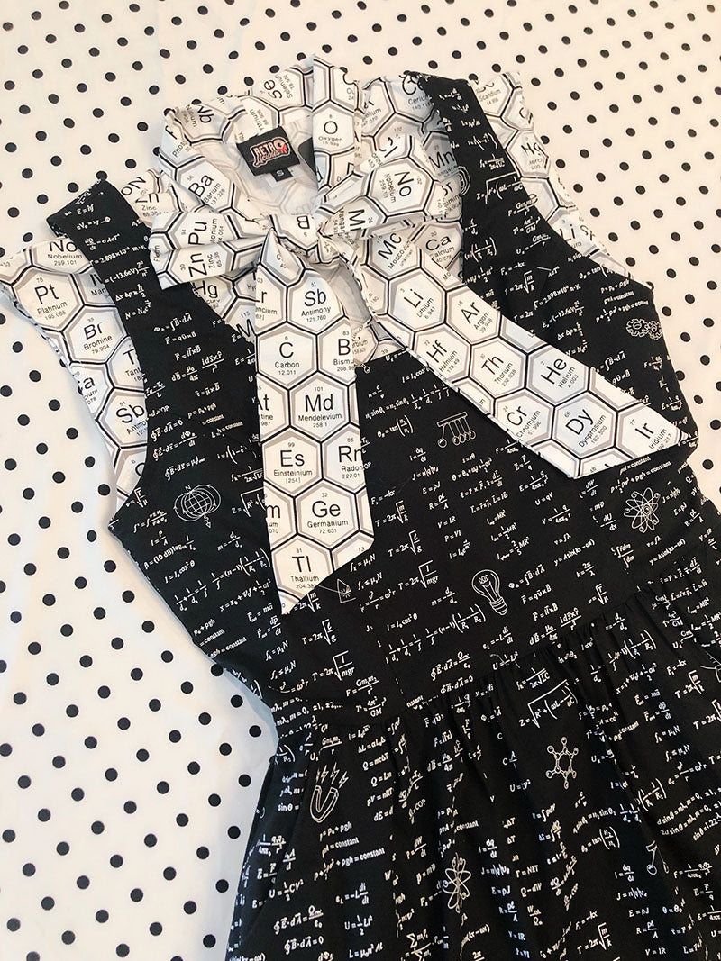 flatlay of our science dress layered with elements bow top